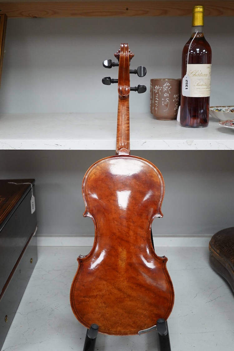 A late 19th century German violin after Pablo Maggini in bird’s eye maple with a fully mounted German bow in a crocodile skin case with retailers ivorine label reading; ‘Edward Withers, 22 Wardour Street, phone City 1899